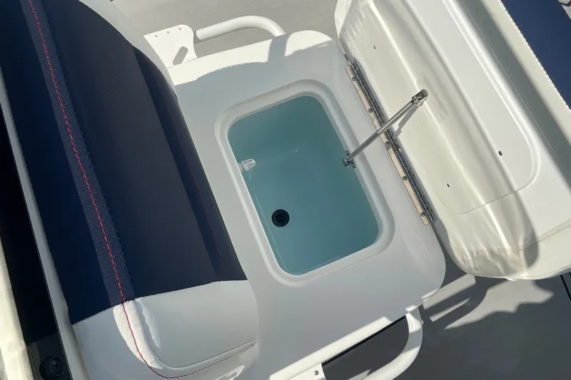 Slide: The Image of Open storage compartment on 2026 Mako 18 Pro Skiff Patriot Edition boat. - 20