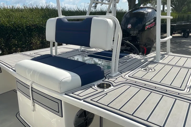 Slide: The Image of 2026 Mako 18 Pro Skiff Patriot Edition boat with cushioned seating and Mercury Pro engine. - 14