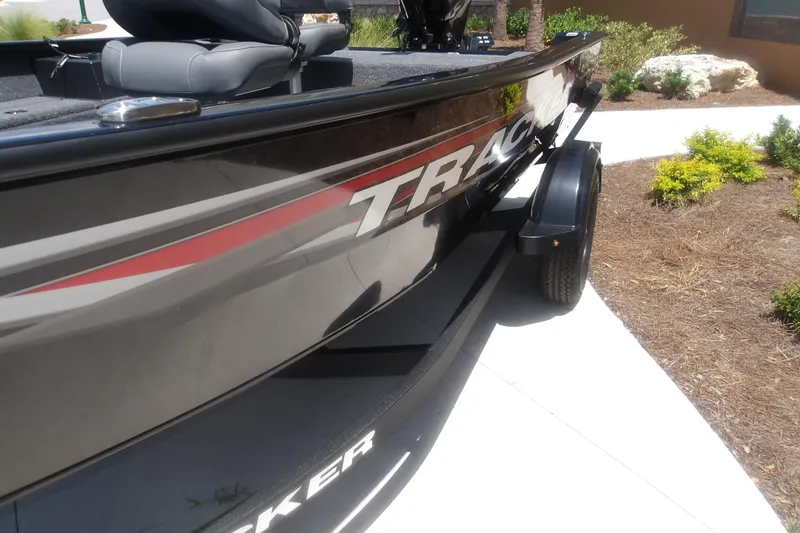 Slide: The Image of 2026 Tracker Super Guide V-16 T boat, sleek design, parked outdoors on a sunny day. - 13