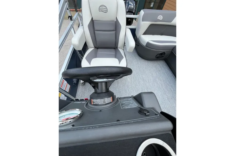 Slide: The Image of 2026 Sun Tracker Bass Buggy 16 XL Select boat interior with steering wheel and seating. - 4