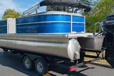 Slide: The Image of 2026 Sun Tracker Party Barge 20 DLX pontoon boat on trailer, parked outdoors. - 4