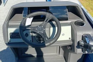 Slide: The Image of 2026 Sun Tracker Party Barge 20 DLX steering console with modern controls and cup holder. - 8