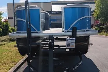 Slide: The Image of 2026 Sun Tracker Party Barge 20 DLX pontoon boat on trailer, parked outdoors. - 2