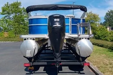 Slide: The Image of 2026 Sun Tracker Party Barge 20 DLX pontoon boat with 90 HP engine, parked outdoors. - 10