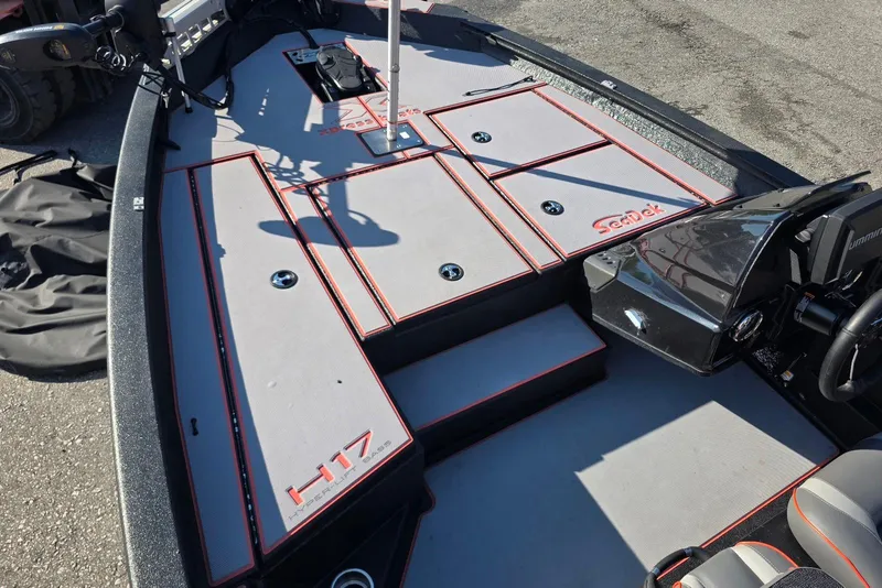 Slide: The Image of 2023 Xpress H17 boat interior with SeaDek flooring, featuring storage compartments and steering console. - 13