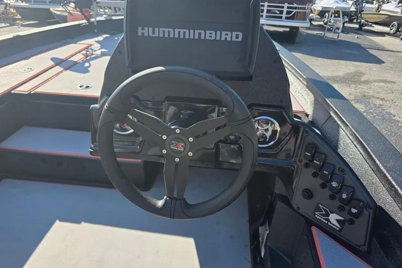 Slide: The Image of 2023 Xpress H17 boat dashboard with steering wheel and Humminbird display. - 17
