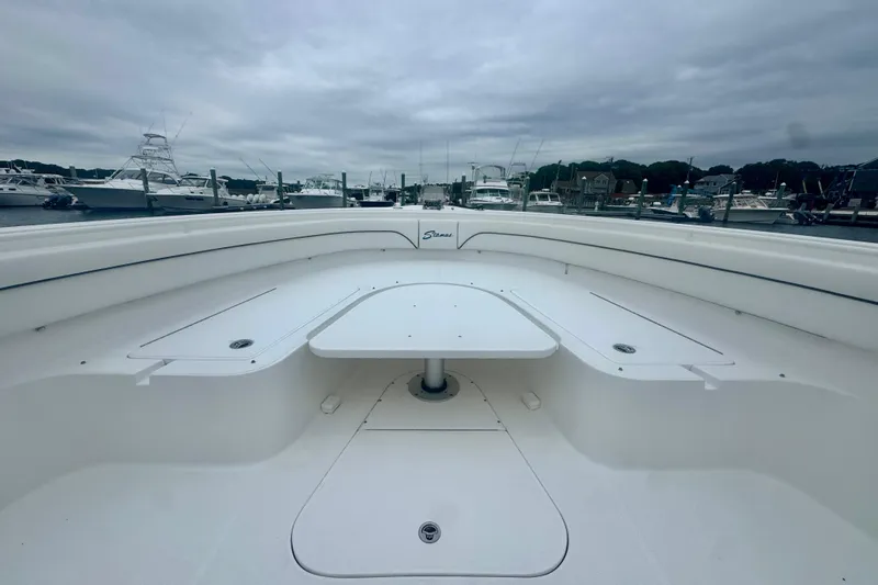 Slide: The Image of 2017 Stamas 390 Tarpon boat interior with seating and table, docked at marina. - 2