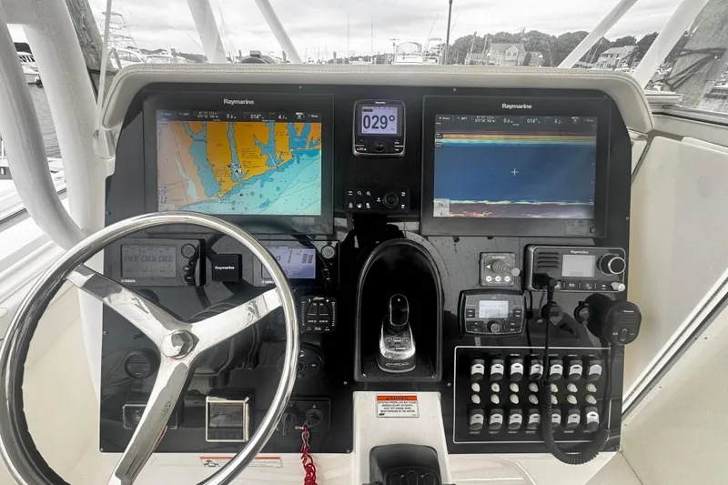 Slide: The Image of Control panel of a 2017 Stamas 390 Tarpon boat with navigation screens and steering wheel. - 8