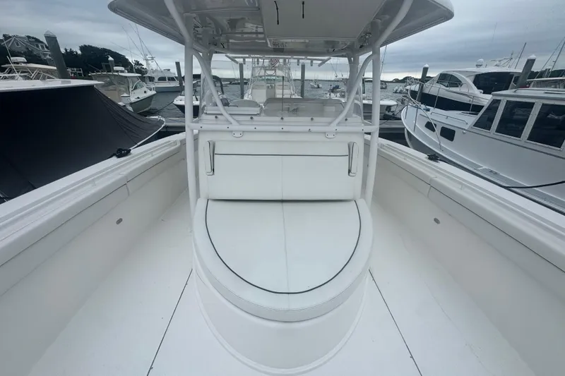 Slide: The Image of 2017 Stamas 390 Tarpon boat interior with white seating and docked boats in background. - 3