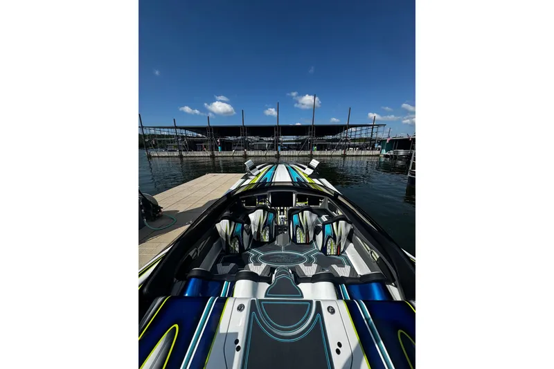 Slide: The Image of 2022 MTI 48 boat docked, showcasing sleek design and vibrant interior under clear blue sky. - 5