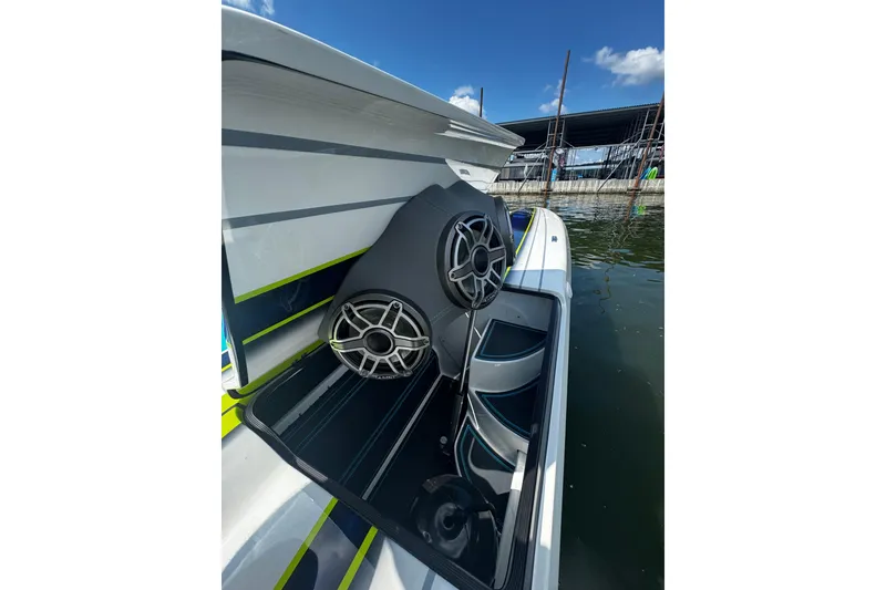 Slide: The Image of 2022 MTI 48 boat with open storage compartment and speakers, docked by the water. - 13
