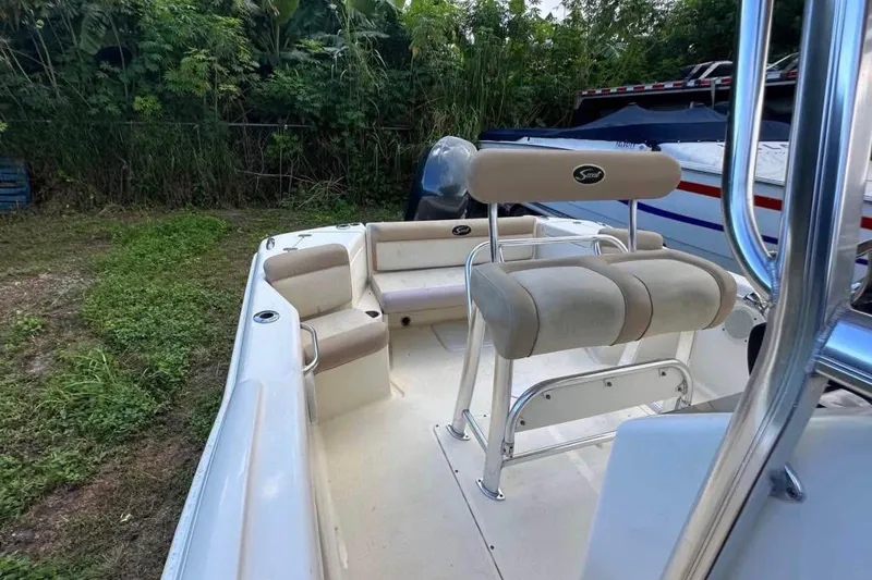 Slide: The Image of 2012 Scout 225 XSF boat interior with seating and lush greenery background. - 7