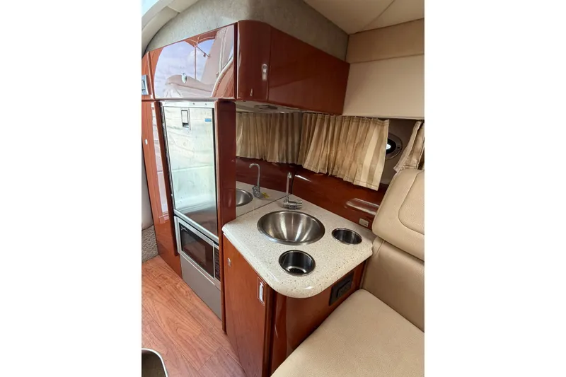 Slide: The Image of Interior of 2009 Formula 310 Sun Sport boat featuring compact kitchenette with sink and storage. - 11