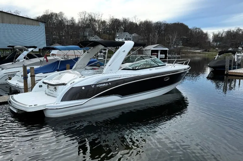 The Image of 2009 Formula 310 Sun Sport boat docked on calm water, surrounded by other vessels. - 0