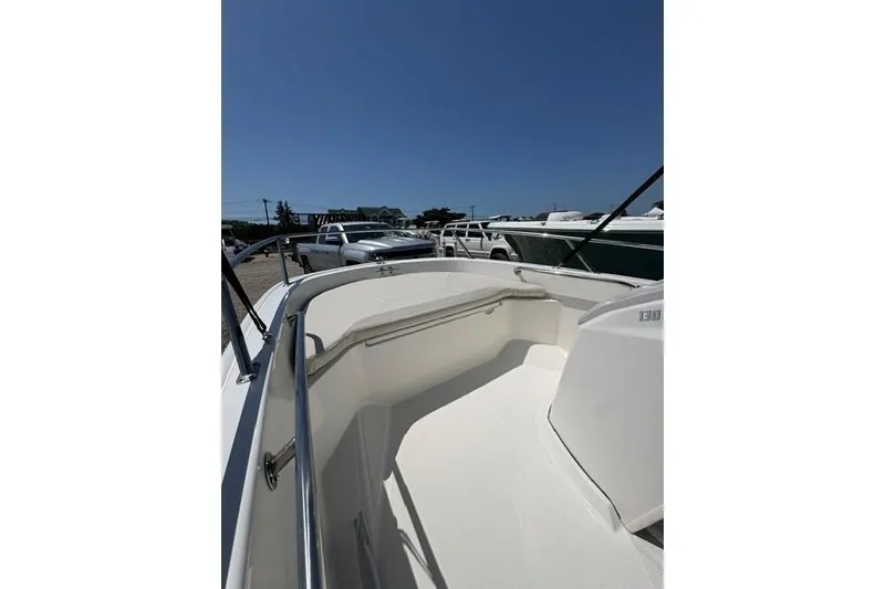 Slide: The Image of 2024 Boston Whaler 130 Super Sport boat interior with sleek design and stainless steel railings. - 8