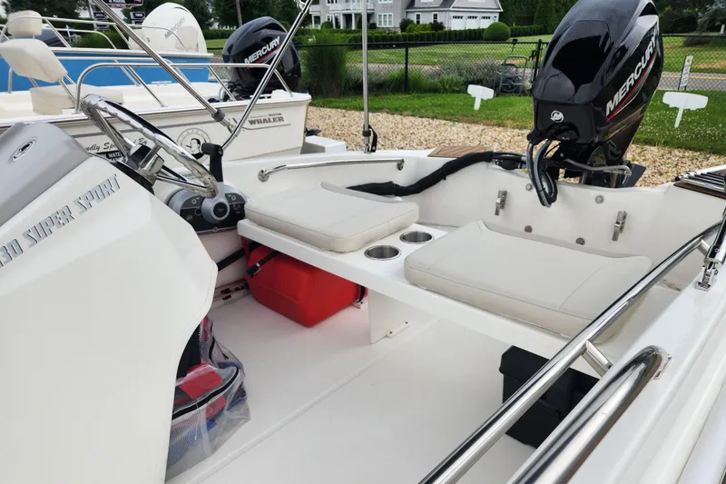 Slide: The Image of 2024 Boston Whaler 130 Super Sport boat interior with Mercury engine and seating. - 4