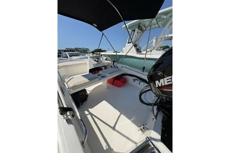 Slide: The Image of 2024 Boston Whaler 130 Super Sport boat interior with seating and canopy. - 5
