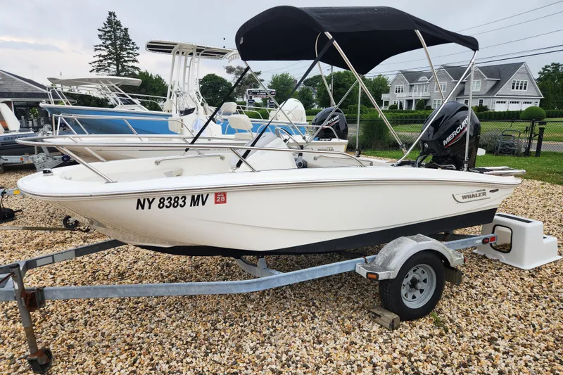 Slide: The Image of 2024 Boston Whaler 130 Super Sport boat on trailer, parked outdoors. - 10