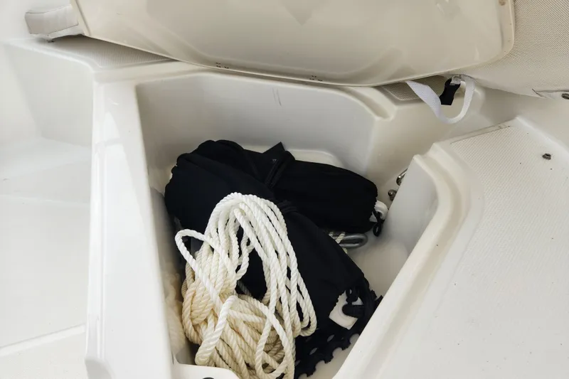 Slide: The Image of Storage compartment of 2024 Boston Whaler 130 Super Sport with rope and gear. - 9