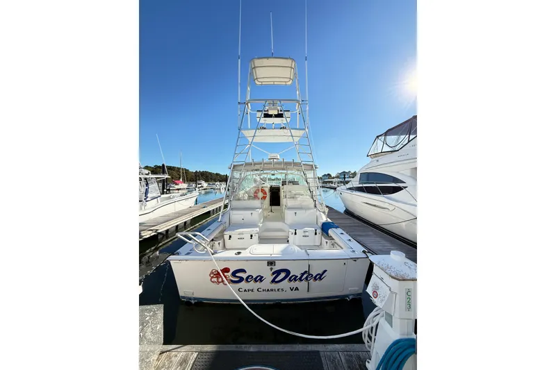 Slide: The Image of 1996 Cabo 35 Express boat docked at marina under clear blue sky. - 8