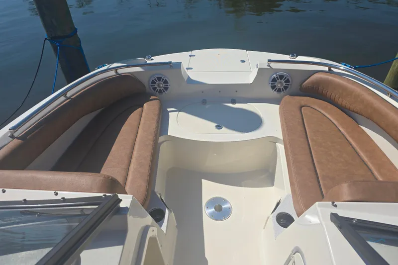 Slide: The Image of Interior view of 2021 Stingray 201 DC boat with brown seating and speakers. - 3