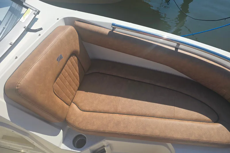 Slide: The Image of 2021 Stingray 201 DC boat with brown cushioned seating, docked on calm water. - 5