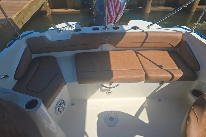 Slide: The Image of 2021 Stingray 201 DC boat interior with tan seating and cup holders. - 8