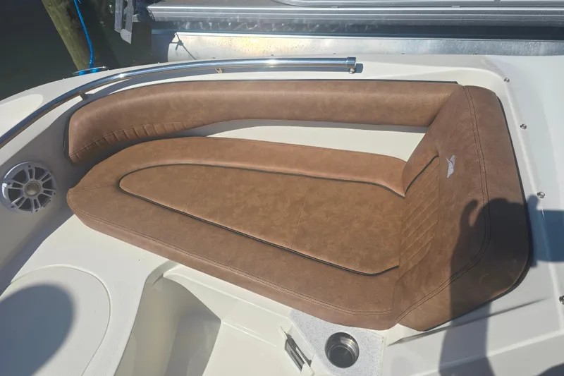 Slide: The Image of Brown leather seating on a 2021 Stingray 201 DC boat, featuring a speaker and cup holder. - 4