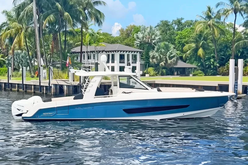 The Image of 2018 Boston Whaler 420 Outrage boat docked near tropical waterfront home. - 0