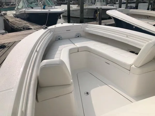 Slide: The Image of 2019 Regulator 23 Forward Seating with spacious cushioned bow seating, docked at a marina. - 13