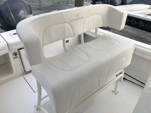 Slide: The Image of White bench seat on a boat with Regulator logo, surrounded by water. - 12