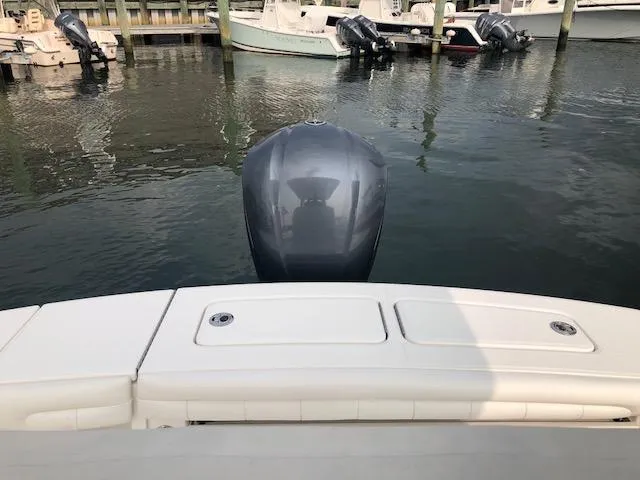 Slide: The Image of A 2019 Regulator 23 Forward Seating boat with an outboard motor, docked in a marina. - 15