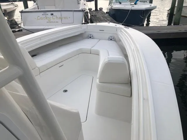 Slide: The Image of The image shows a 2019 Regulator 23 Forward Seating boat with white upholstery at a dock. - 14