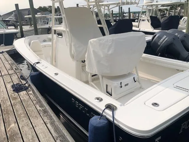 Slide: The Image of A 2019 Regulator 23 Forward Seating boat docked. It features a blue hull. - 3