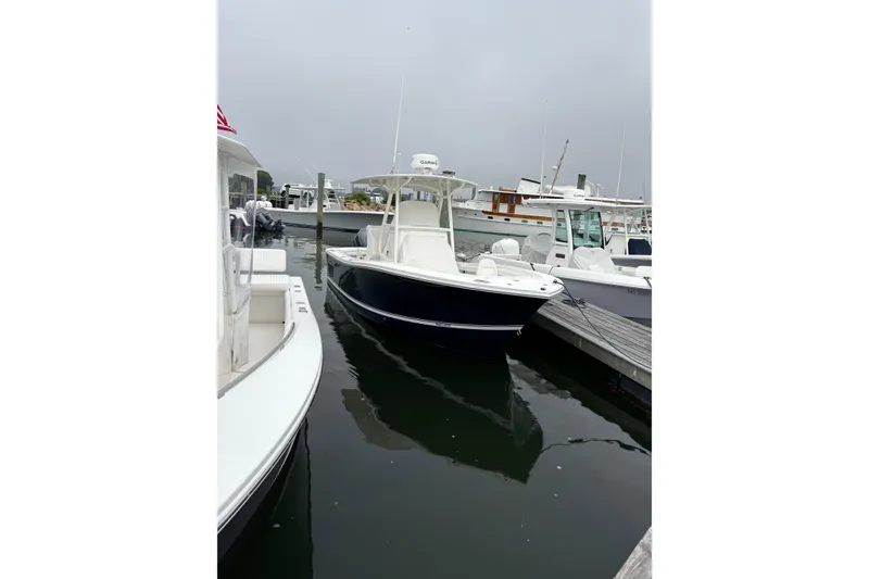 Slide: The Image of 2019 Regulator 23 Forward Seating boat docked at a marina on a cloudy day. - 6