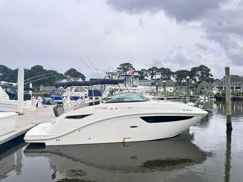 Slide: The Image of 2015 Sea Ray 260 Sundancer docked at a marina under cloudy skies. - 3