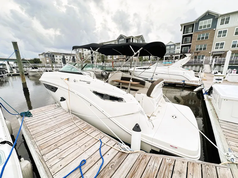 Slide: The Image of 2015 Sea Ray 260 Sundancer docked at marina with modern buildings in background. - 2