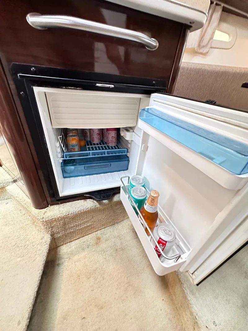 Slide: The Image of Mini fridge inside 2015 Sea Ray 260 Sundancer, stocked with beverages. - 25