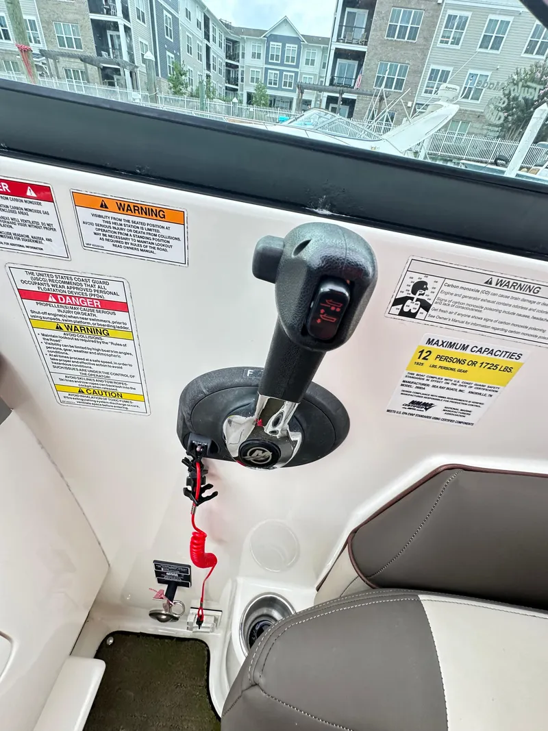 Slide: The Image of 2015 Sea Ray 260 Sundancer control panel with throttle and safety warnings. - 13
