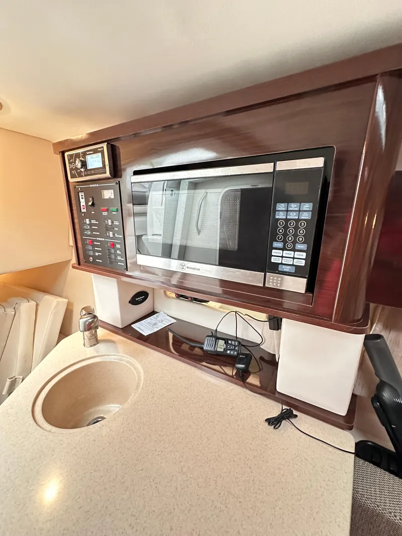 Slide: The Image of 2015 Sea Ray 260 Sundancer interior with microwave and control panel. - 21