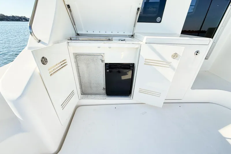 Slide: The Image of 2004 Silverton 48 Convertible yacht with open storage compartments and mini fridge on deck. - 27