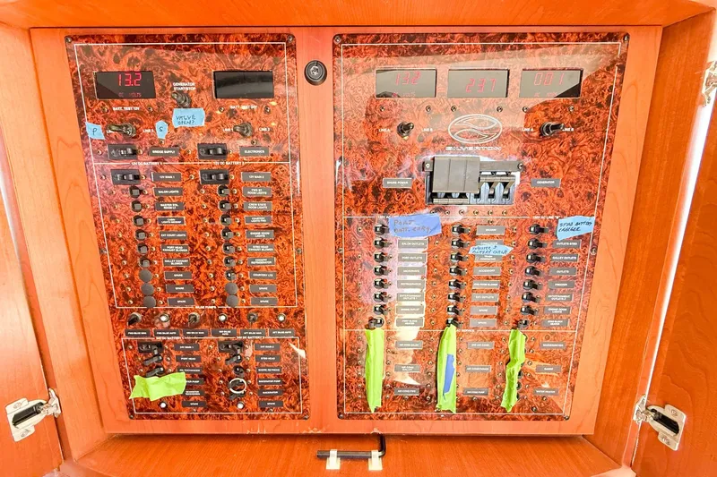 Slide: The Image of Electrical panel of a 2004 Silverton 48 Convertible yacht with labeled switches and meters. - 67
