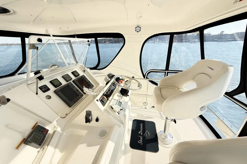 Slide: The Image of 2004 Silverton 48 Convertible yacht helm with modern controls and panoramic windows. - 16
