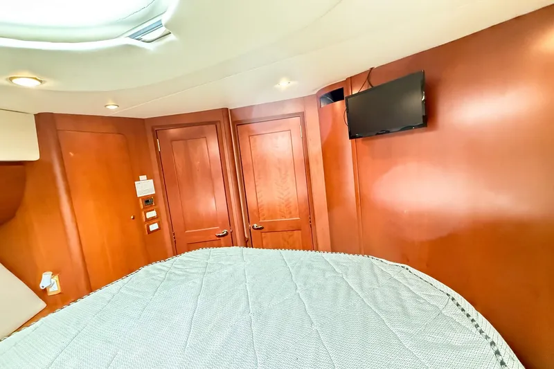 Slide: The Image of Interior of 2004 Silverton 48 Convertible yacht with wood paneling and mounted TV. - 61