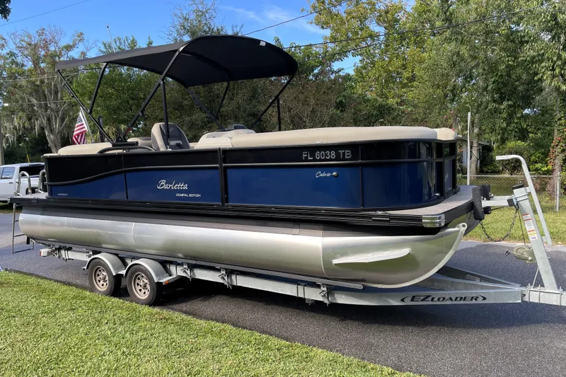 Slide: The Image of 2022 Barletta Cabrio 22QC pontoon boat on trailer, parked outdoors with canopy. - 3