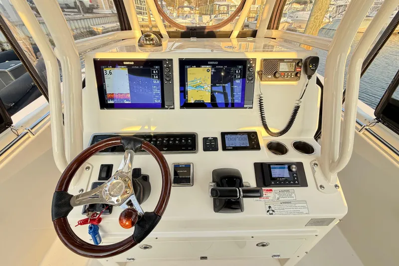 Slide: The Image of 2016 Cobia 296 Center Console helm with dual Simrad displays and modern controls. - 6