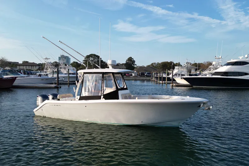 Slide: The Image of 2016 Cobia 296 Center Console boat docked in marina, clear sky background. - 3