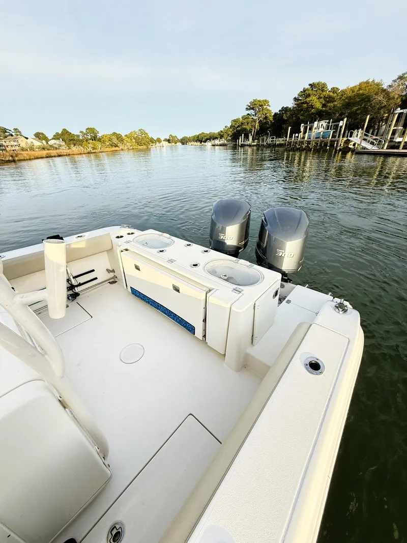 Slide: The Image of 2016 Cobia 296 Center Console boat with dual engines on a calm river. - 10