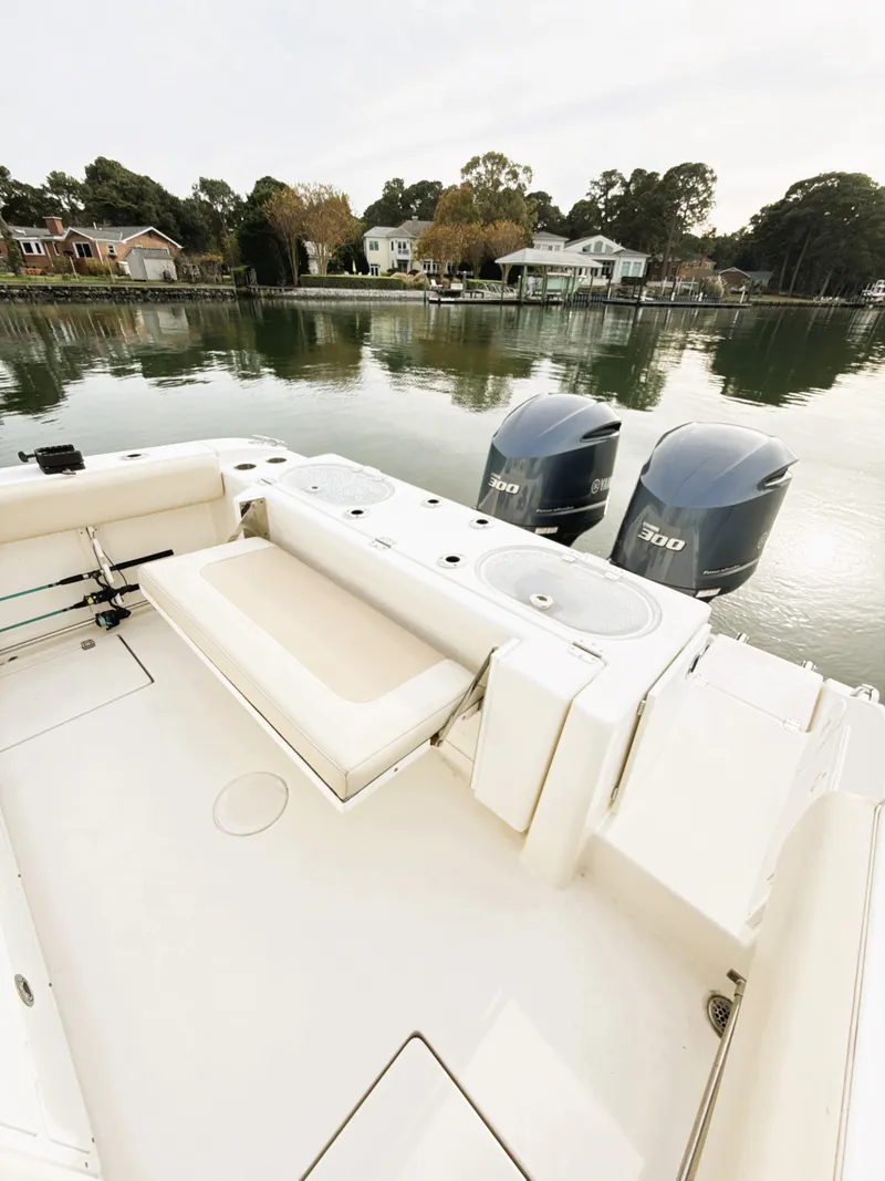 Slide: The Image of 2016 Cobia 296 Center Console boat with dual engines docked by a serene waterfront. - 13