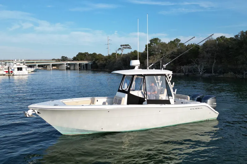 Slide: The Image of 2016 Cobia 296 Center Console boat on calm water, with scenic background. - 1